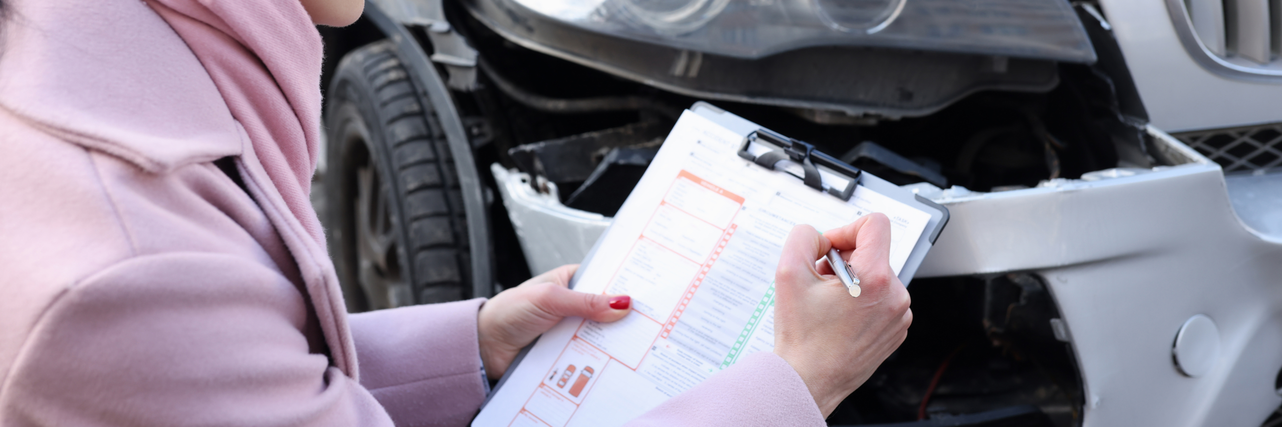 Une conductrice remplissant un constat à l'amiable suite à un accident.