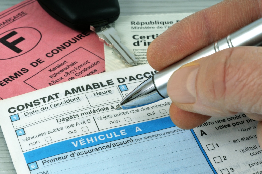 Un conducteur remplissant un constat à l'amiable suite à un accident.